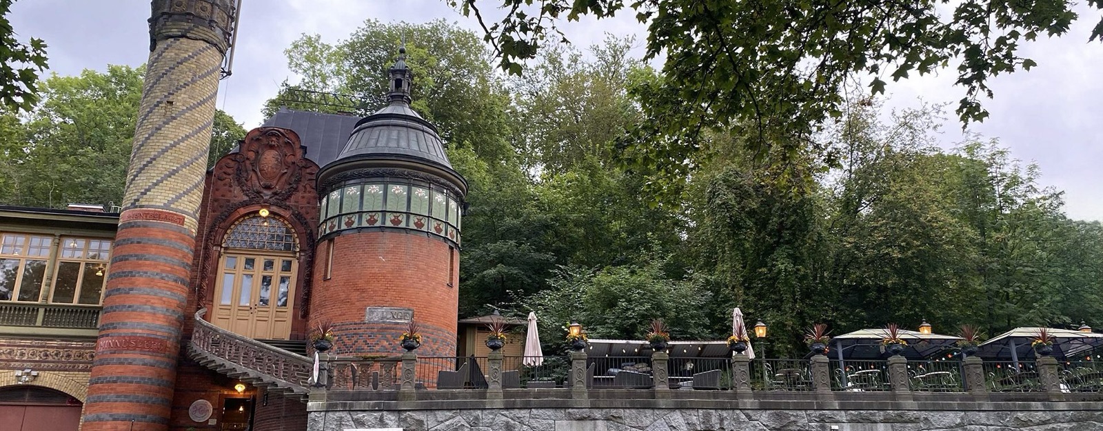 Skånska Gruvan med sitt torn i tegel, och uteserveringens bord utanför entrén