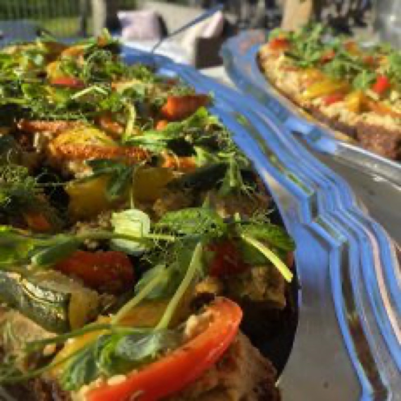 Cateringfat med grillade grönsaker och sallad på blått linne